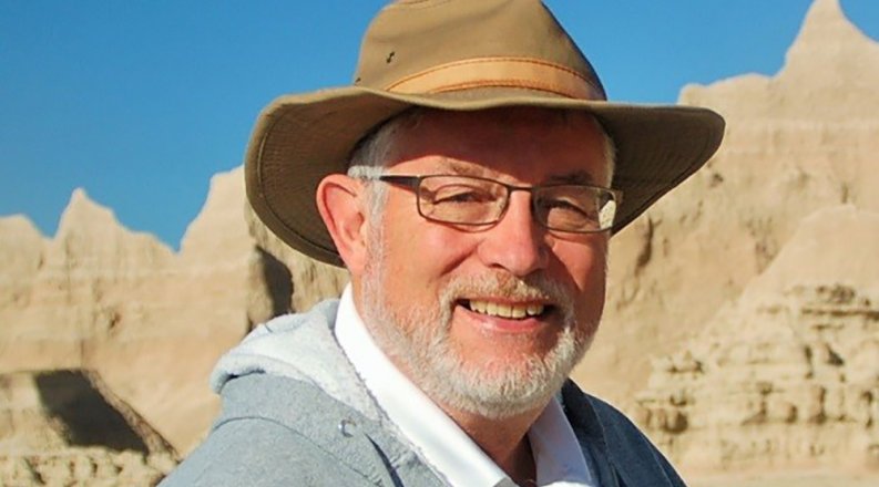 A photo of Richard Whittecar with mountains in the background.