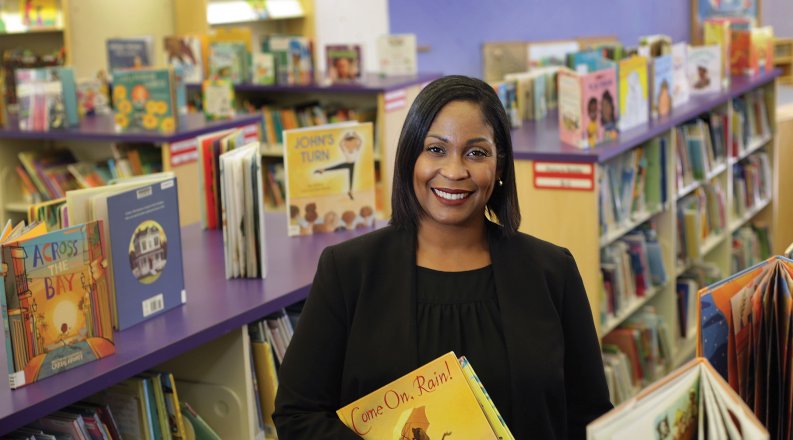 a woman stands in front of bookshelves