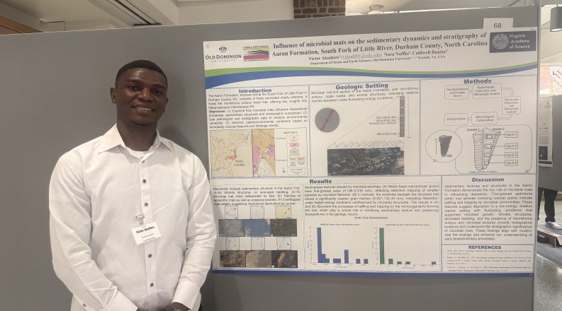 Victor Akudoro standing in front of a poster