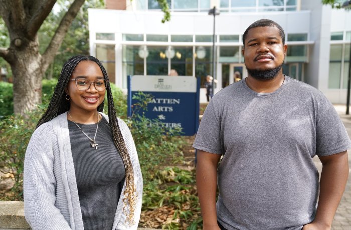 Two people stand in front of a building on ODU's campus.