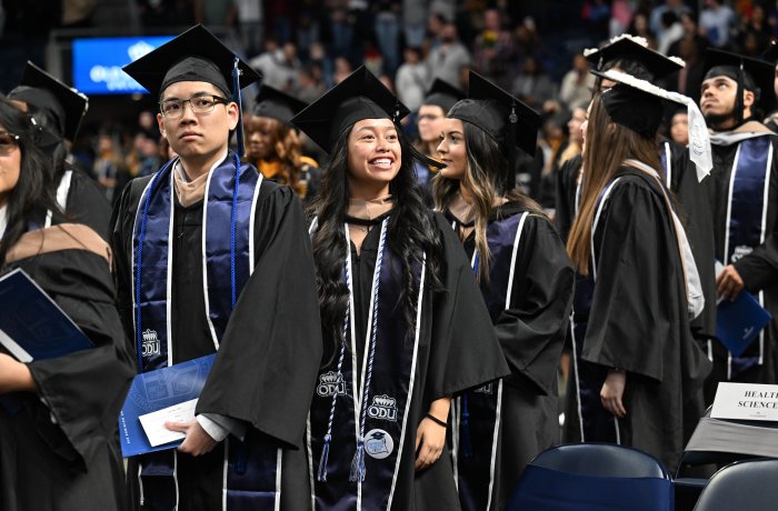 A group of graduates stand together at commencement