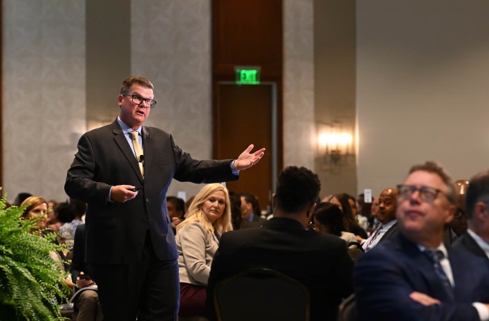 A man, Bob McNab, talks to a roomful of people.