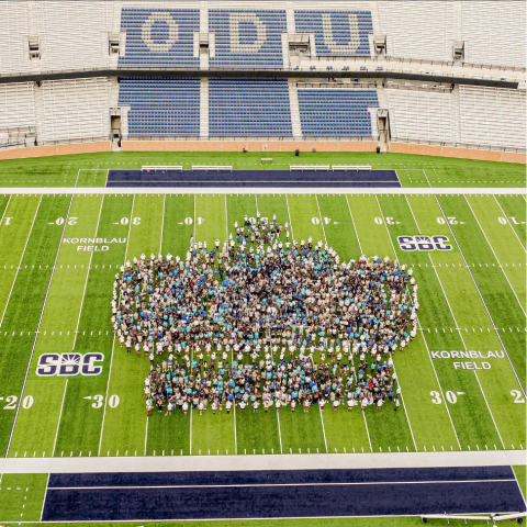 class of 2028 students in the shape of a crown on the football field