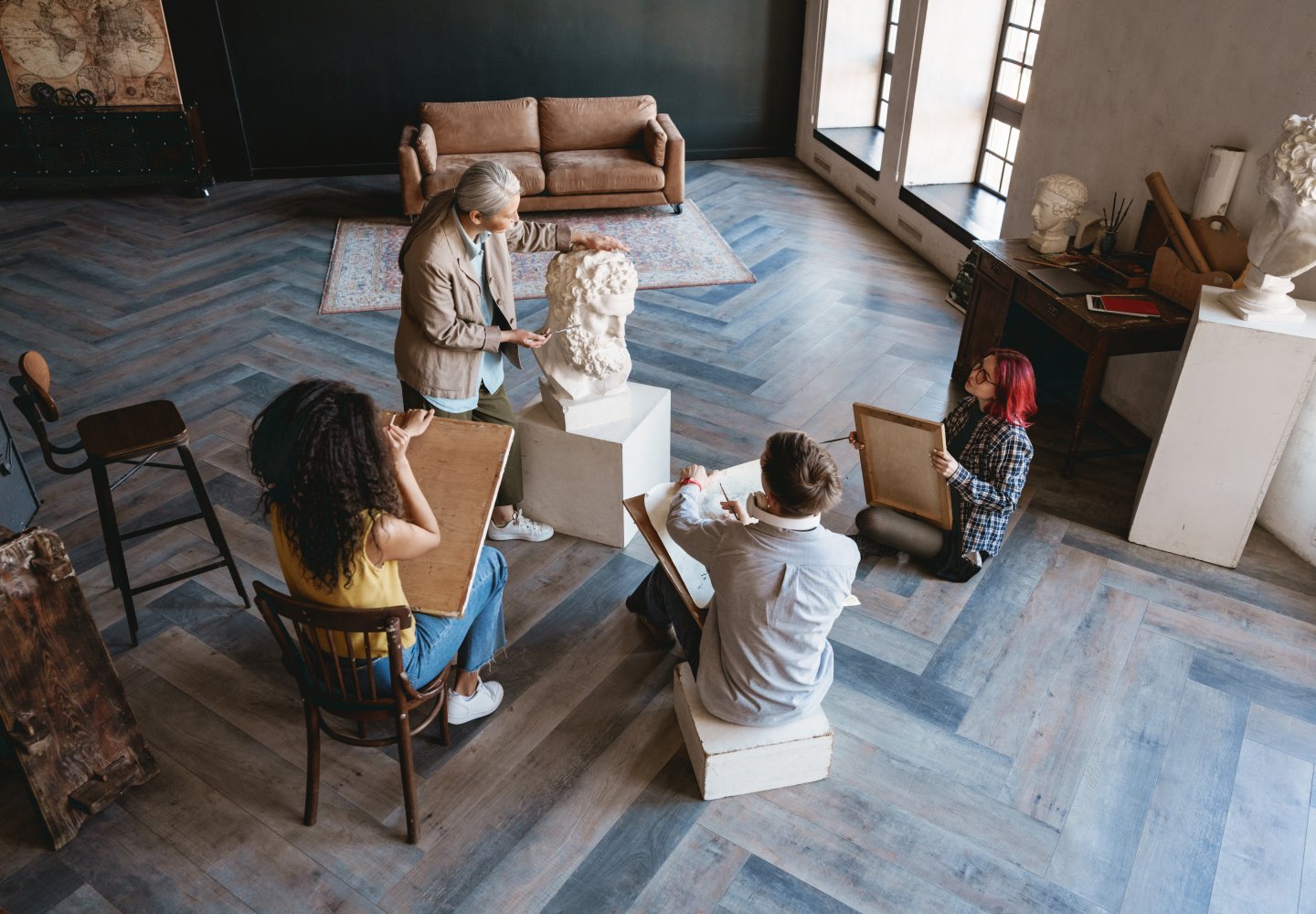 Art teacher talks with her students during class in art studio