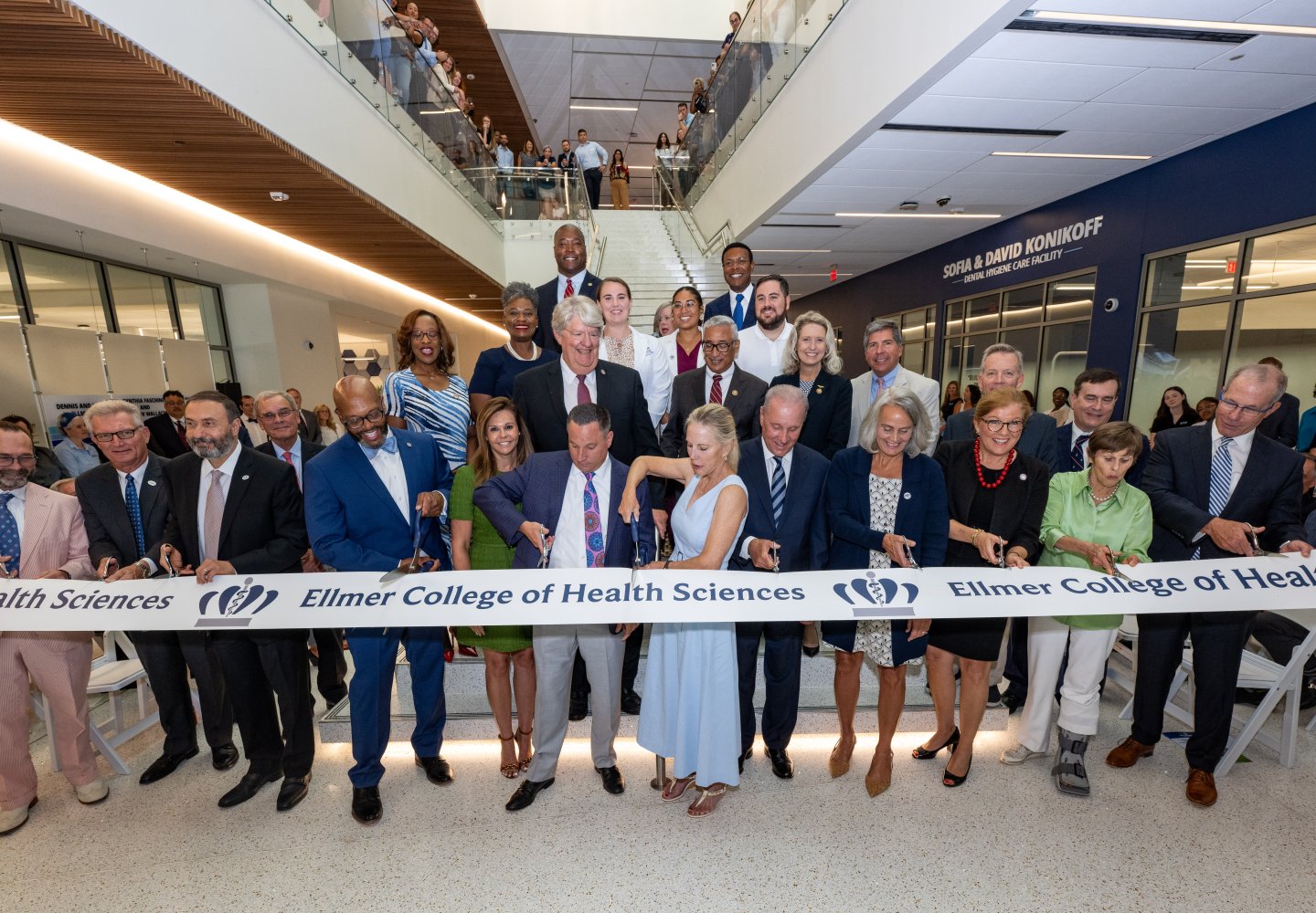 group of people cutting a grand opening ribbon