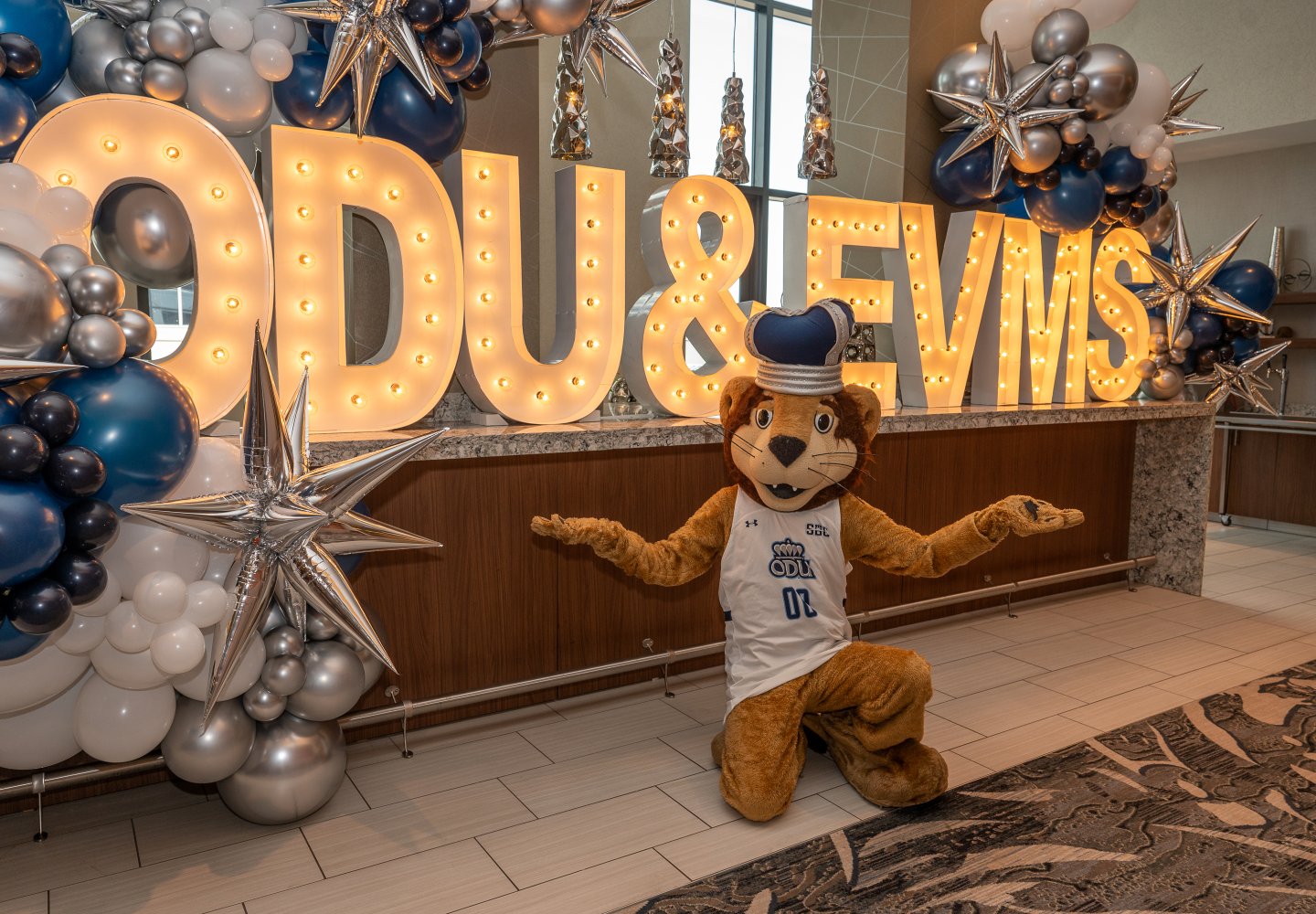 ODU's mascot poses in front of an ODU/EVMS sign. 