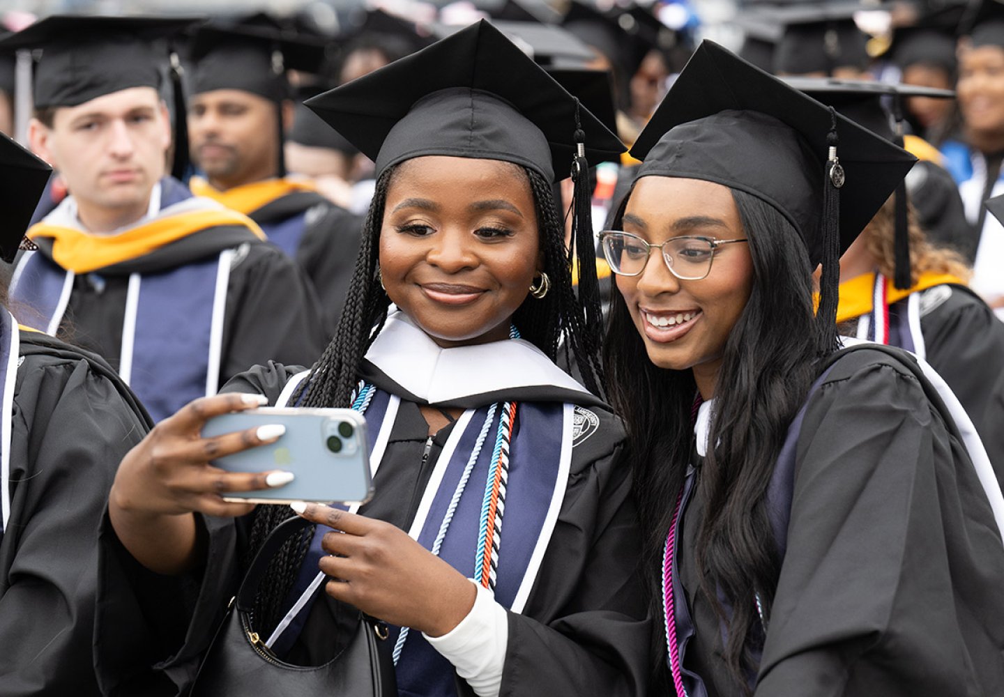 Students pose for a selfie during the undergraduate Commencement exercise Saturday, May 4, 2024.
