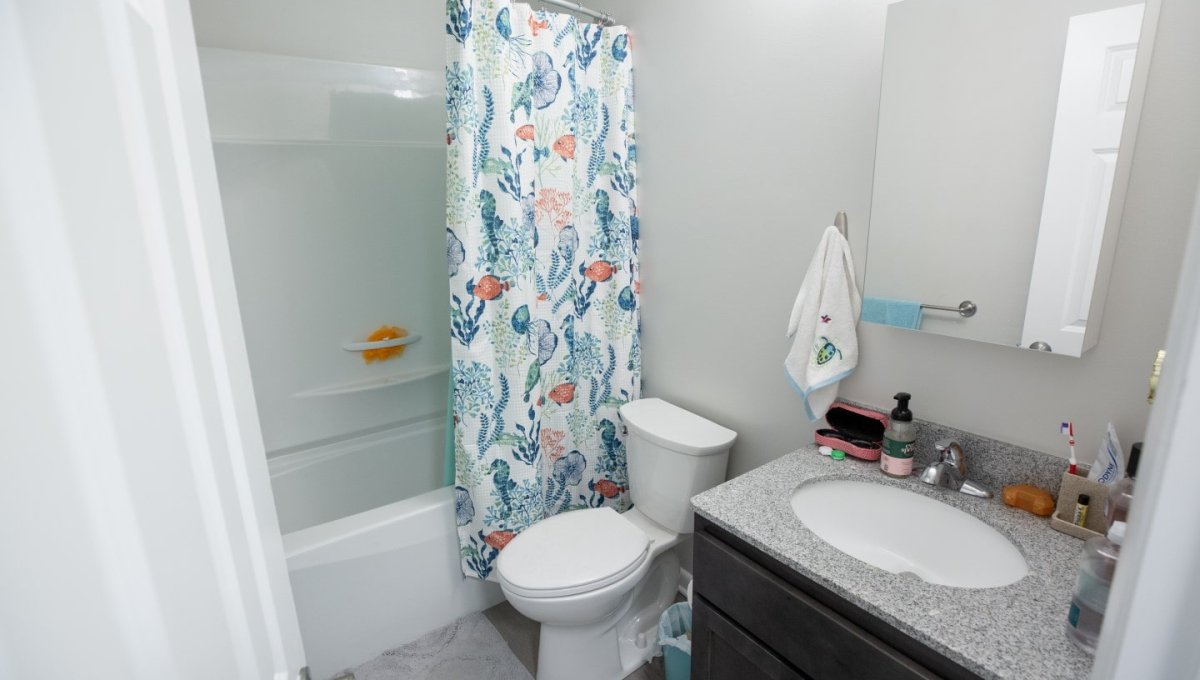 Bathroom with ocean themed curtain and decoration.