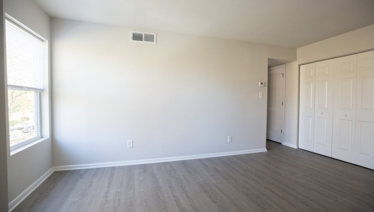 Unfurnished living room area with window and closet.