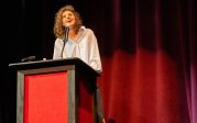 Lauren Oyler speaks at a podium.