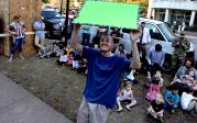 Dakota Christian holds a large, bright-green sign to signal that it is OK to drop a pumpkin during the 2016 Pumpkin Drop. 