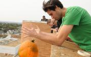 A student releases a pumpkin for its descent during the annual pumpkin drop.