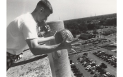 In 1999, senior chemistry major Nathan Schmidt prepares to drop a pumpkin from the roof of the Batten Arts and Letters Building.