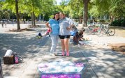 Two students pose for a photo on ODU's campus in front of a crown they painted on the sidewalk. 