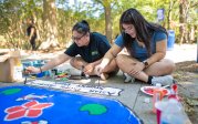 Students paint a crown on a sidewalk on ODU's campus. 