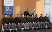 A group of Army ROTC students sit in a row.