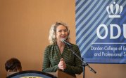 A woman stands at a podium.