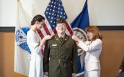 An Army ROTC student is pinned with a rank insignia by family members.