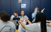 A group of students hand out plastic bags at a food drive packing event. 