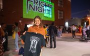 A woman holds up a T-shirt.