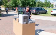 A student pushes a cart full of dorm items.