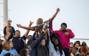 A group of students hold up a fellow student.