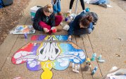 Students paint a crown on the sidewalk on ODU's Kaufman Mall.