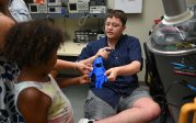 Jacob Lamkhidda shows a girl a prototype of a prosthetic hand