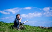 Kindra McDonald Greene sits on the grass in a field.