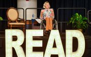 A woman in a wheelchair talks on a stage.