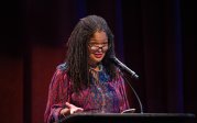 A woman speaks from a podium.