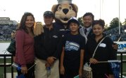 a family stands outside with a school mascot 