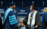 A student shakes hands with President Hemphill.