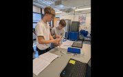 Students working with science equipment on fluid hydraulics.