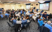 A group of people sit at tables. 