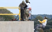 A person rappels down the side of a building.