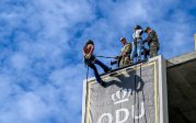 A person rappels down the side of a building.