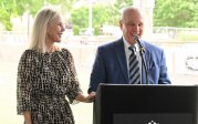 Dennis and Jan Ellmer speak at a podium.