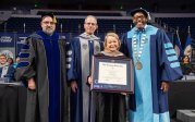 group of people pose with a degree