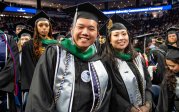 Graduates stand together during commencement