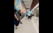 Seated FAME class participants do warm-ups in the clinic hallway
