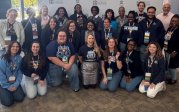 ODU counseling students, faculty, and alumni in front of a Virginia School Counselor Association Backdrop.