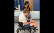 Leslie Prom, DPT, watches a video on Cody Bennett's phone showing him playing adaptive golf