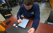 Student drawing on a tablet in a lab