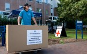 A student stands by a big box.