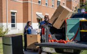 A man lifts a box out of a truck.