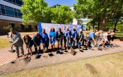 A group of people participate in a groundbreaking event.
