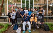 A group of student pose for a photo on a bench. 