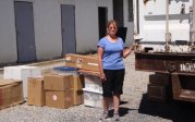 Woman standing beside a truck with supplies.