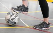 A person rests their foot on a soccer ball.